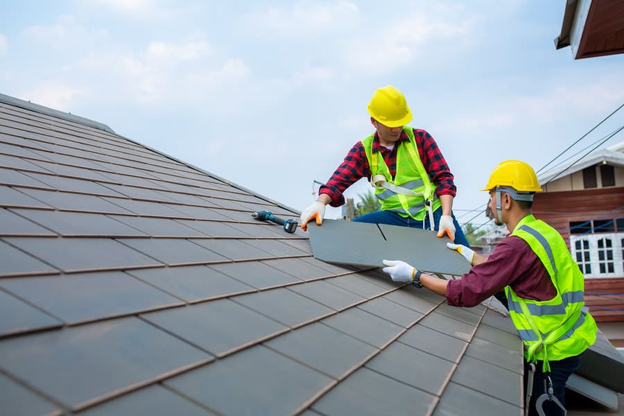 Roofing crew checking a residential roof surface