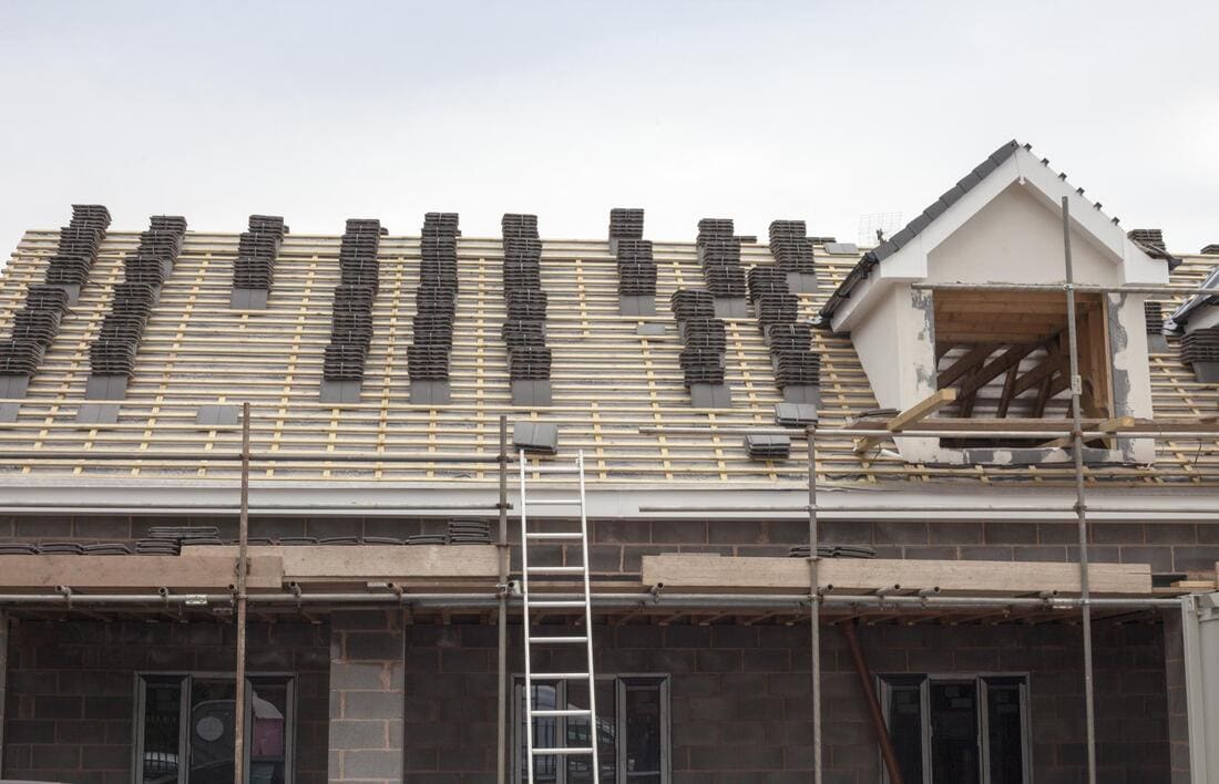 Roofing crew working on a tear-off from scaffold